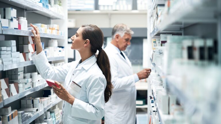 Two pharmacists checking products on their shelves.