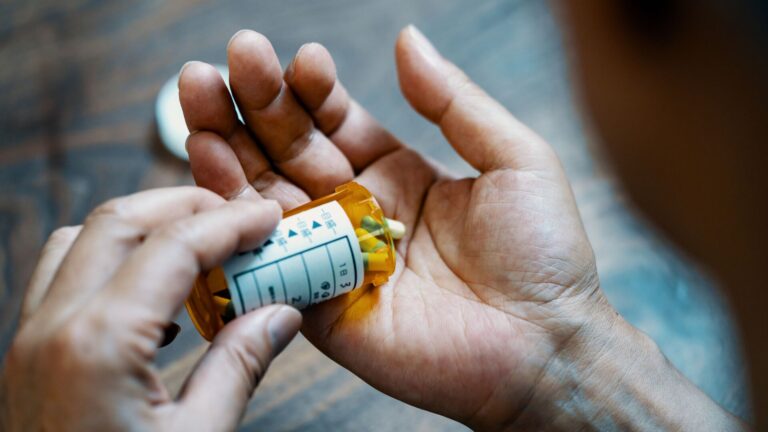 Pill bottle is placed in the hands of an elderly recipient.