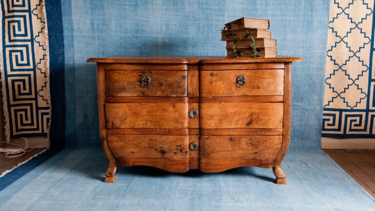Old antique dresser made of wood against a sky blue drapery representing recommerce for old furniture and a recent TD Cowen retail visionaries podcast with Cherish,