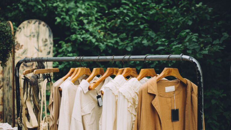 Sustainable wardrobe concept, sustainable fashion, clothing rack outdoors with dresses in the woods. Cuyana's CEO Karla Gallardo joins Cowen Insights to discuss sustainable fashion, responsible material sourcing & educating the consumer.