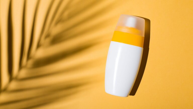 Sunscreen, beauty product, palm leaf shadow, against yellow background. Amanda Baldwin, CEO of Supergoop! discusses the company's brand innovation, entrepreneurship, leadership, and current consumer trends.