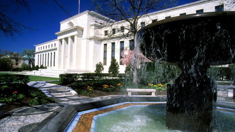 Image of the federal reserve building in front of a water fountain meant to convey the passing of time before Fed Now is released next year.