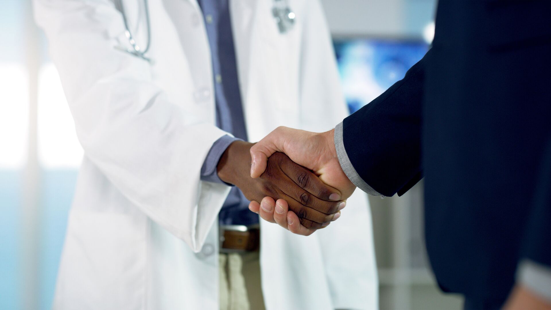 A doctor and somebody in business making a deal, representative of deal making in the biotech industry.