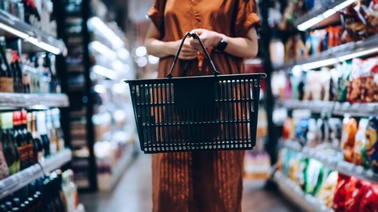 Woman in a shopping aisle looking for groceries, considering both the value consumer dollar and her health & wellness
