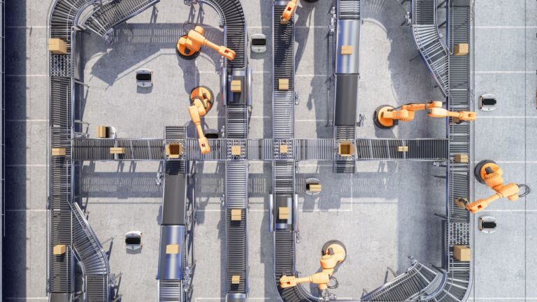 Overhead view of robotic arms placing boxes on conveyor belts.