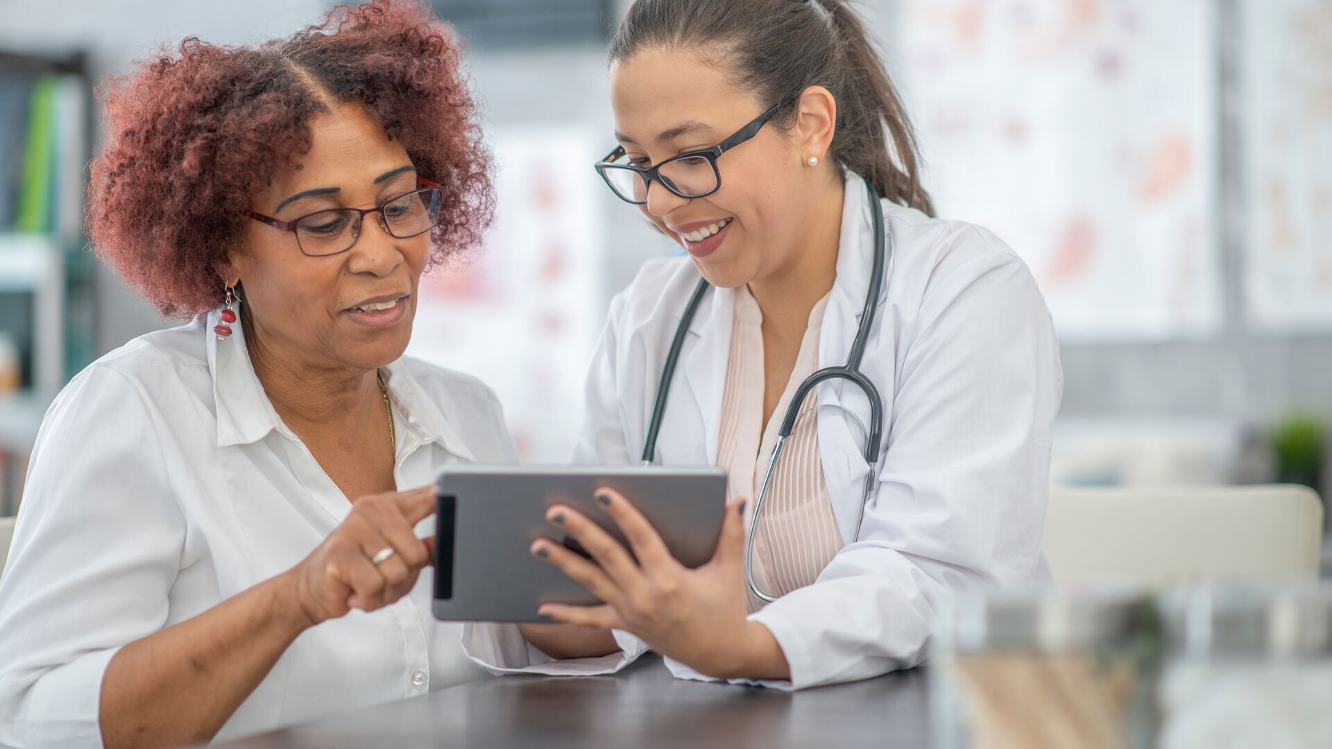 Applied Health Care data as health care professionals go over data with a patient on a tablet.