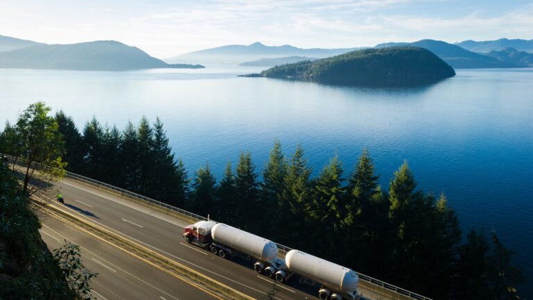 A truck driving down a scenic and lush green mountain side, representing sustainability, energy transition, renewable diesel, and other next gen fuels.