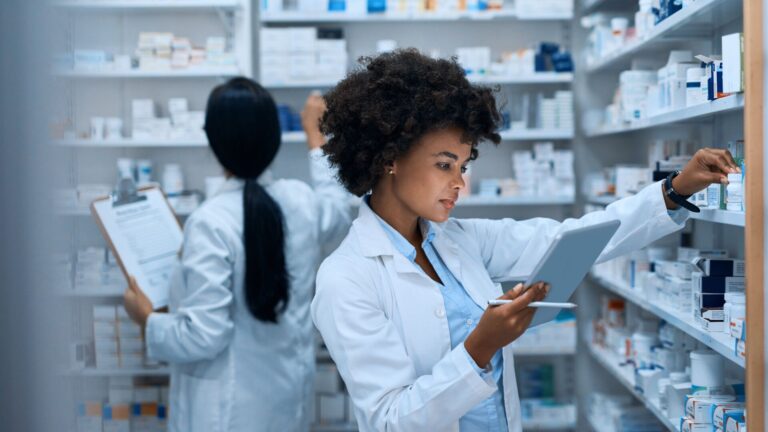 Two female pharmacists working together in the back of a pharmacy.