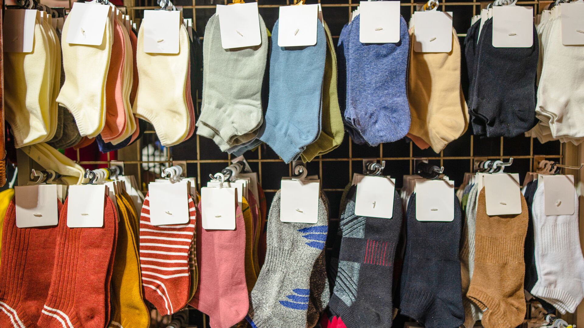 An assortment of colorful wool socks are set on display in the apparel section of a department store.
