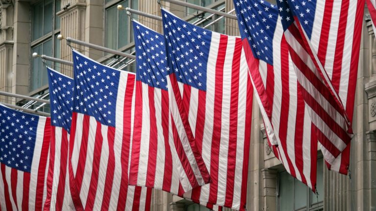 American flags are aligned above the street in New York City.