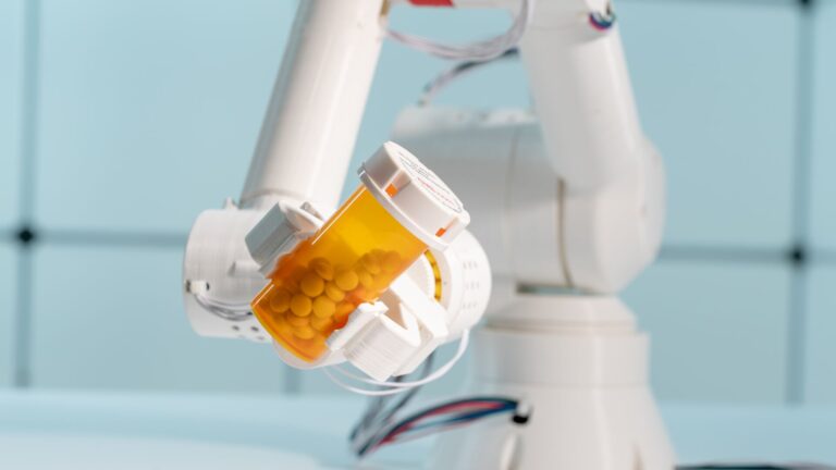 Robotic arm holding out a generic pill bottle.